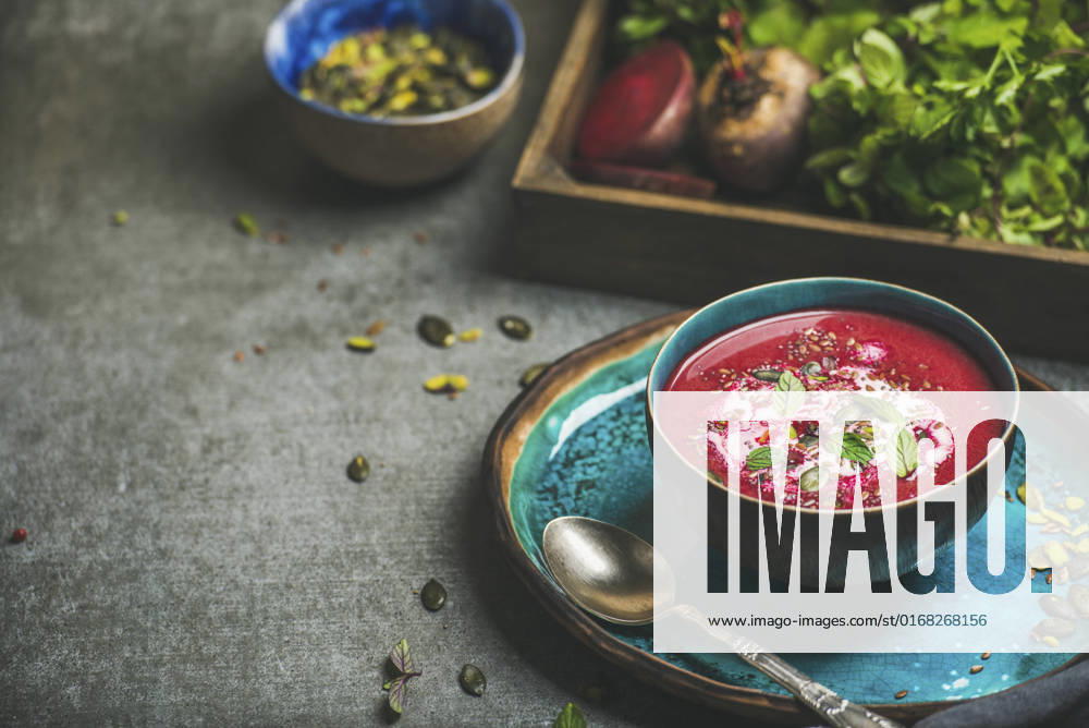 Spring detox beetroot soup with mint, chia, flax and pumpkin seeds in blue ceramic bowl over grey concrete background Spring detox beetroot soup with mint, chia, flax and pumpkin seeds in blue ceramic bowl over grey concrete background, copy space. Dieting, clean eating, vegan, vegetarian, weight loss food concept