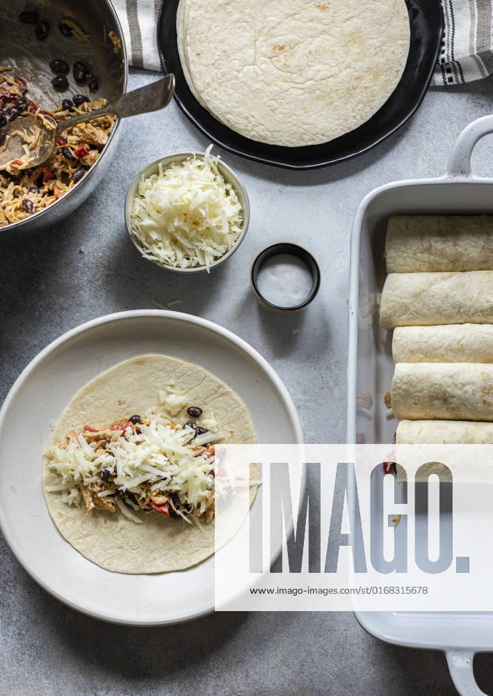IMAGO Creative, Food, Enchiladas Enchiladas in the making. Tortillas on the plate filled with cheesy chicken and black beans