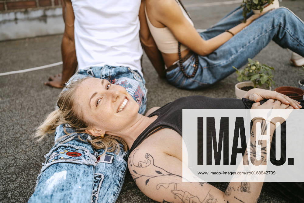 IMAGO Kreativ: Urbane Kultur - Sommer auf den Dächern Portrait of smiling young woman resting head on man s lap Germany, Berlin, model released, property released