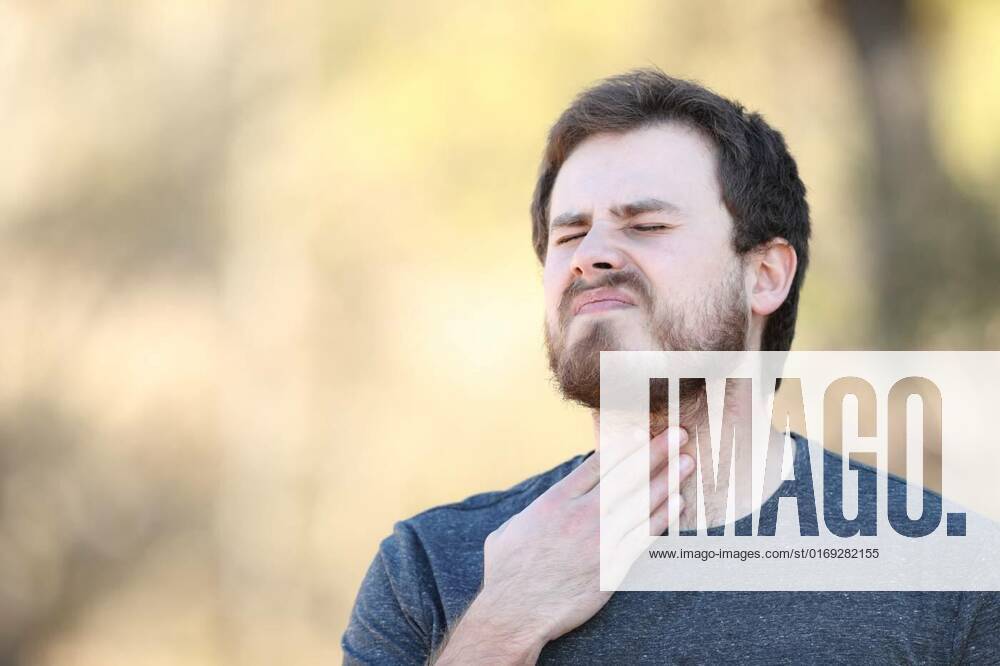 IMAGO Creative, Gesellschaft, Leisure Sickness Man suffering sore throat in nature, Overwhelmed man suffering sore throat in nature, Overwhelmed man suffering sore throat in nature model released, Symbolfoto , 14.03.2022,