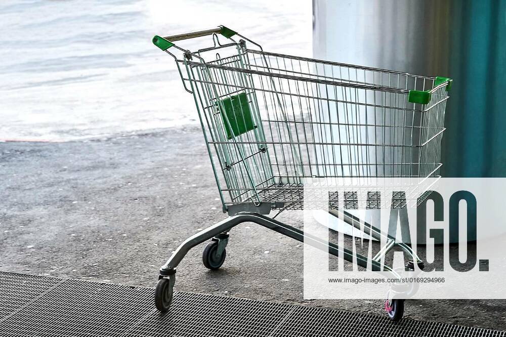 An empty shopping cart stands in front of the entrance to the shopping center, An empty shopping cart stands in front of the entrance to the shopping center. High quality photo, An empty shopping cart stands in front of the entrance to the shopping center. High quality photo, 20.03.2022,