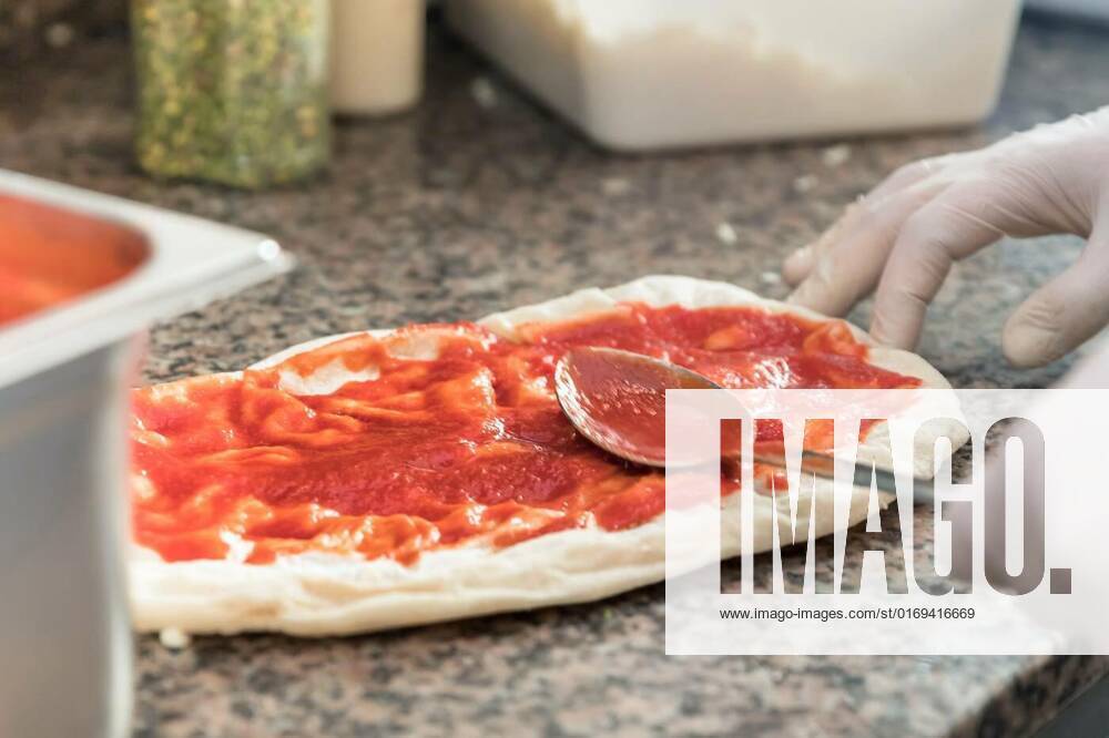Pizza preparation, Fresh original Italian raw pizza, dough preparation in traditional style. Applying a tomato sauce., Fresh original Italian raw pizza, dough preparation in traditional style. Applying a tomato sauce., 11.05.2022,