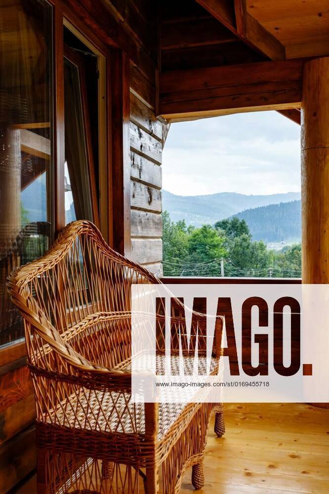 Terrace with wicker bench on wooden balcony with mountain views., Beautiful outdoor terrace with wicker bench on wooden balcony with mountain views. Wicker products. Decor elements of a wooden cottage for relaxing in the mountains., Beautiful outdoor terrace with wicker bench on wooden balcony with mountain views. Wicker products. Decor elements of a wooden cottage for relaxing in the mountains., 30.05.2022,
