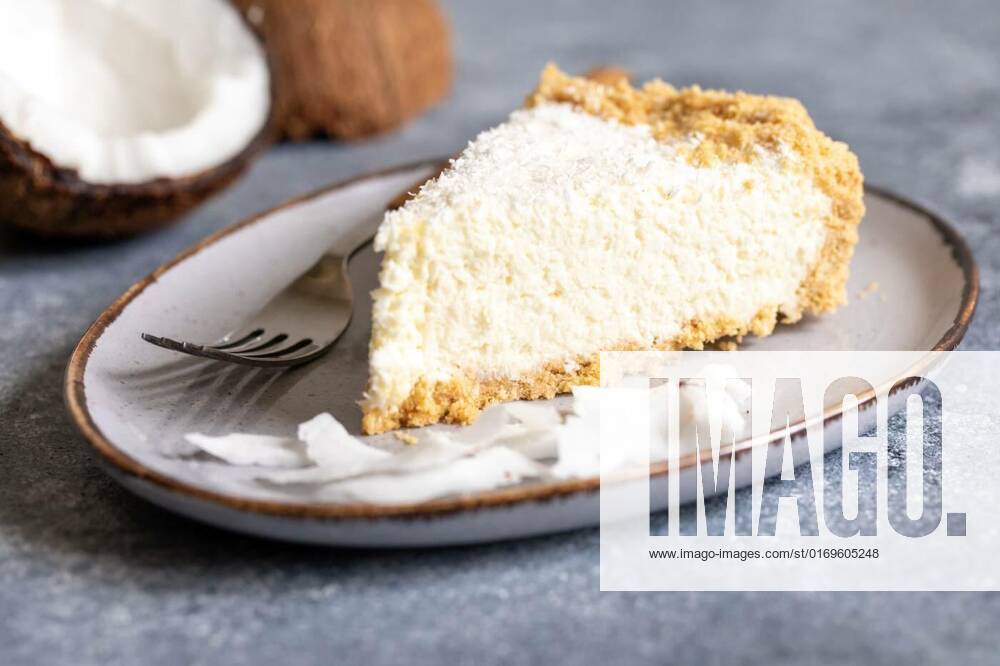 Piece of coconut cheesecake on a plate with fresh coconut, piece of coconut cheesecake on a plate with fresh coconut., piece of coconut cheesecake on a plate with fresh coconut., 01.08.2022,