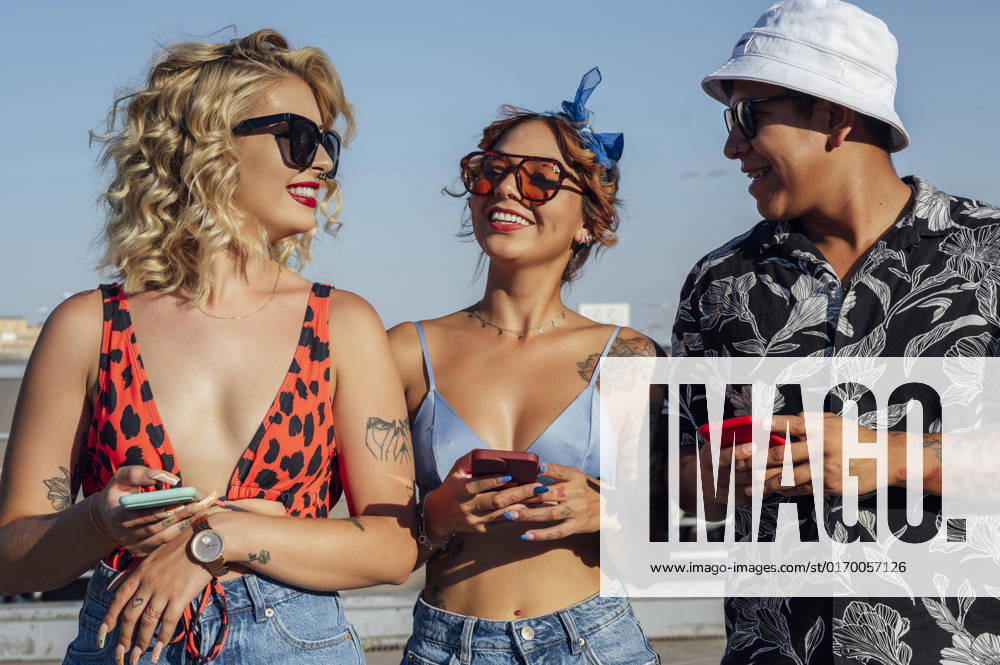 Man and women with mobile phones standing together on sunny day model released, Symbolfoto property released, PGF01257