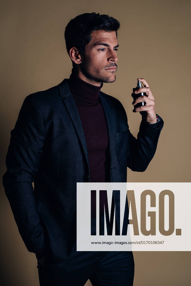 Young business man in a studio applying perfume, Model released DavidPrado_NachoStudio_4