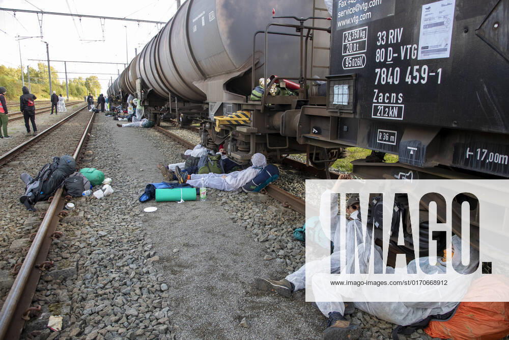 Illustration picture shows demonstraters blocking and chained on a TotalEnergies railway during the start of a large-scale blockade of an oil infrastructure of TotalEnergies in Belgium, organized by the coalition Code Rood , in Feluy - Seneffe, Saturday 08 October 2022. This will be the first action of this new coalition, which invites everyone to participate. With massive civil disobedience, Code Rood wants to point out the fossil fuel industry s responsibility in the climate crisis and demand a socially and environmentally just transition NICOLASxMAETERLINCK 46559983