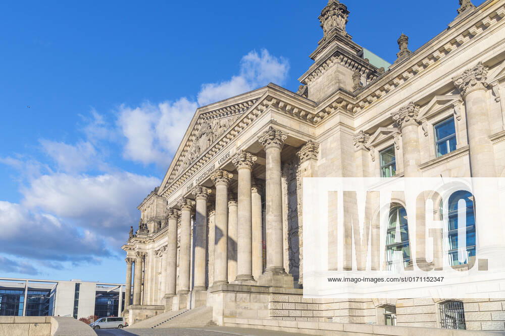 Symbolbild Deutscher Bundestag Deutschland, Berlin, Bundestag: Froschperspektive Seitenansicht vom sonnenbeschienenen Portal des Reichstagsgebäudes DEM DEUTSCHEN VOLKE , blauer Himmel mit weißen Wolken im Hintergrund. Seitlich Paul-Löbe-Haus.