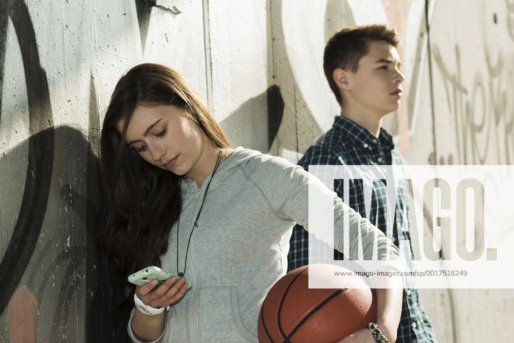 Teenage couple with basket ball and smartphone model released UUF000171