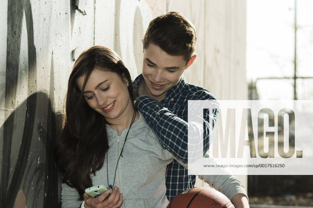 Teenage couple with basket ball and smartphone model released UUF000172