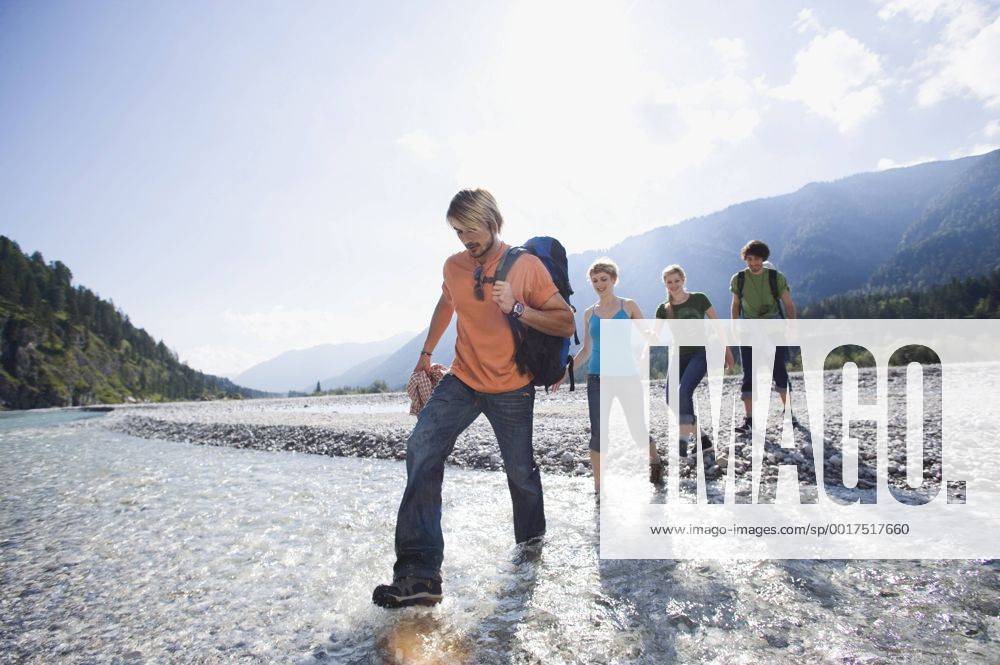 Germany, Bavaria, Tölzer Land, Young friends walking through river model released WESTF09910