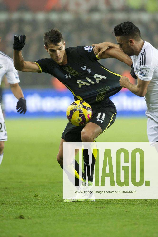 Football - 2014 2015 Premier League - Swansea City vs. Tottenham Hotspur Erik Lamela of Tottenham Hotspurs has his shirt held by Neil Taylor of Swansea at The Liberty Stadium. COLORSPORT WINSTON BYNORTH