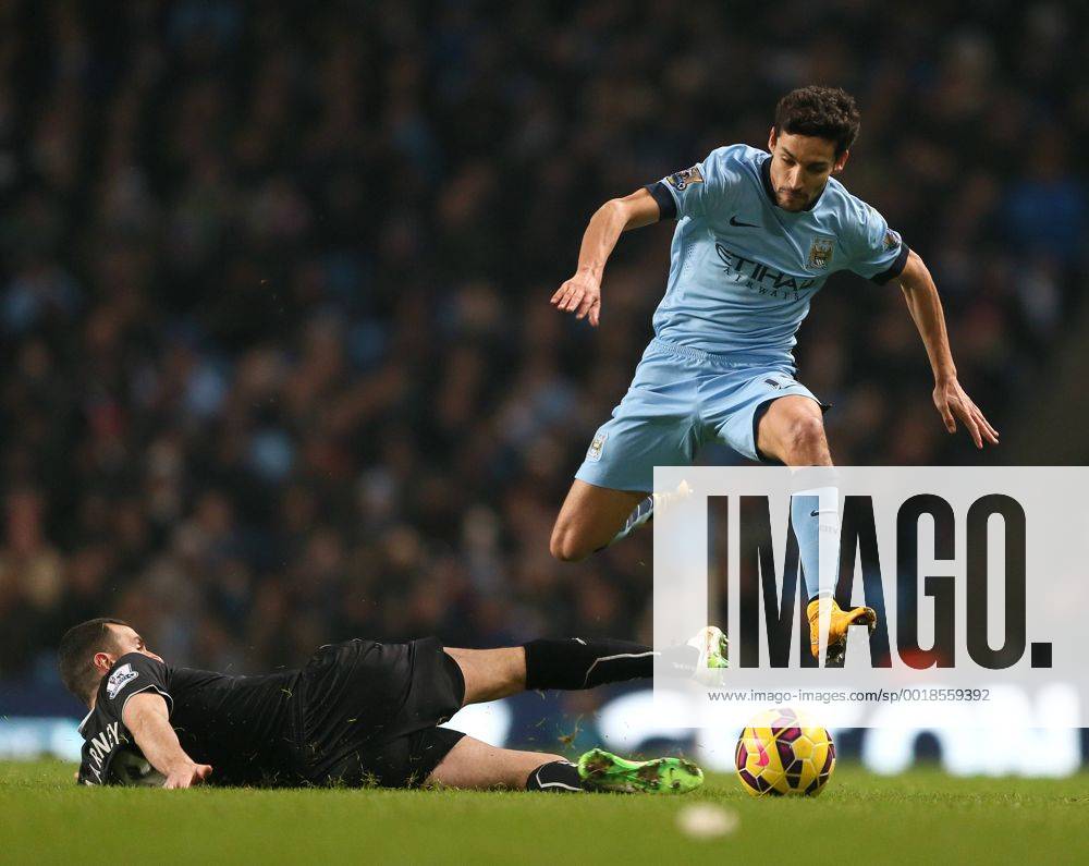 Jesus Navas of Manchester City jumps over a tackle by Dean Marney of Burnley - Barclays Premier League - Manchester City vs Burnley FC - Etihad Stadium - Manchester - England - 28th December 2014 - Picture Simon Bellis Sportimage .