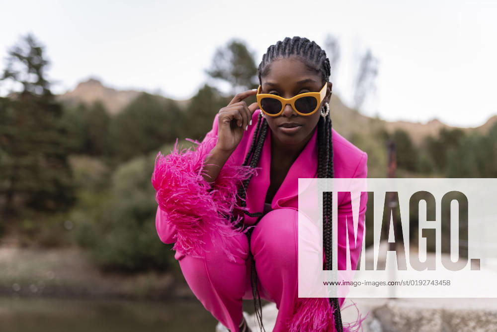 IMAGO Creative, Lifestyle, Barbiecore Woman with braided hair wearing sunglasses model released, Symbolfoto, JCCMF07496