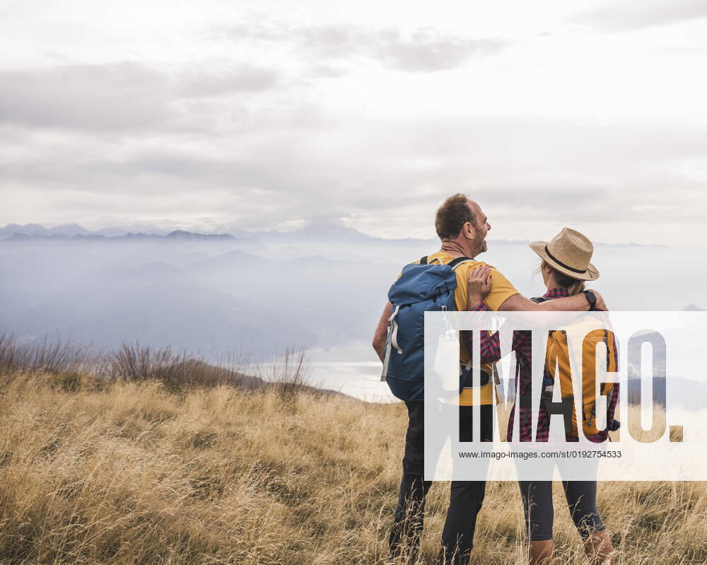 Happy mature couple with arm around standing together on grass model released, Symbolfoto, UUF27672