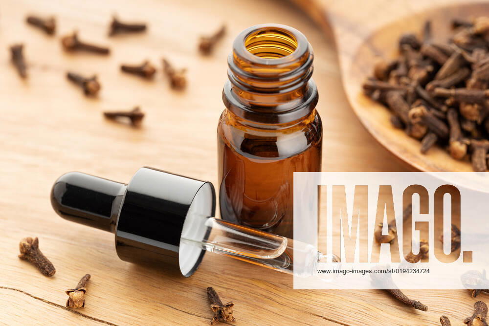Clove essential oil on bottle on wooden table. Alternative medicine Clove essential oil on bottle on wooden table. Alternative medicine