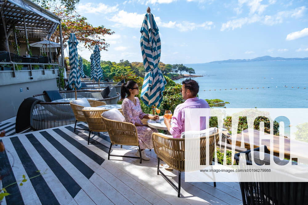 Couple having lunch at an restaurant looking out over the ocean of Pattaya Thailand, man and woman having dinner in restaurant by the ocean in Pattaya couple having lunch at a restaurant looking out over the ocean of Pattaya Thailand, man and woman having dinner in a restaurant by the ocean in Pattaya.