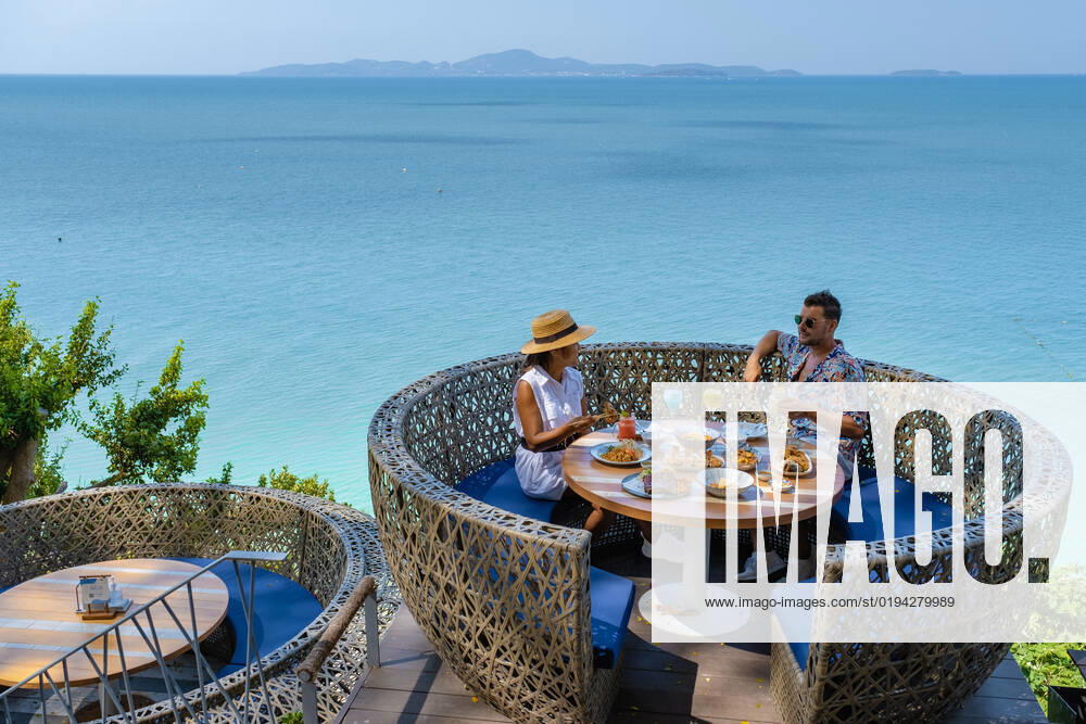 Couple having lunch at an restaurant looking out over the ocean of Pattaya Thailand, man and woman having dinner in restaurant by the ocean in Pattaya couple having lunch at a restaurant looking out over the ocean of Pattaya Thailand, man and woman having dinner in a restaurant by the ocean in Pattaya.
