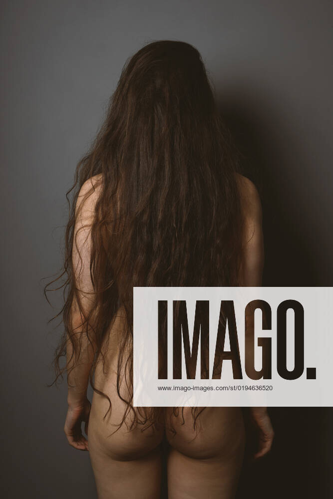 Naked woman has hair down to her bum back view of unrecognizable naked young woman - she has hair down to her bum