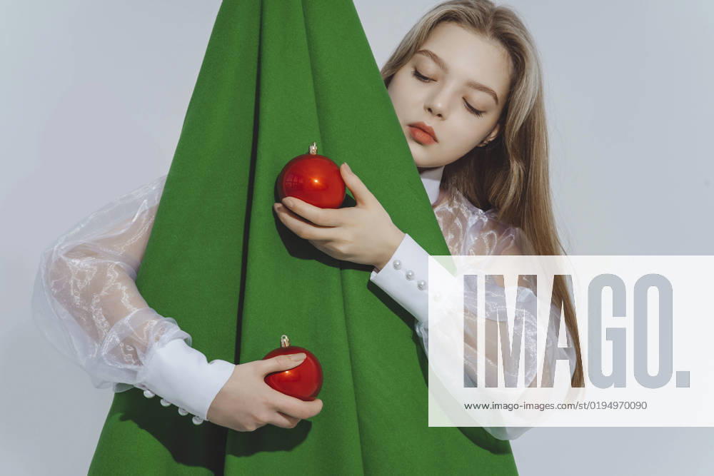 Girl holding red baubles embracing abstract Christmas tree against white background model released, Symbolfoto, IEF00221