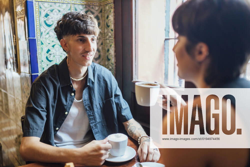 Hipster man looking at girlfriend holding coffee cup in cafe model released, Symbolfoto property released, JRVF03193