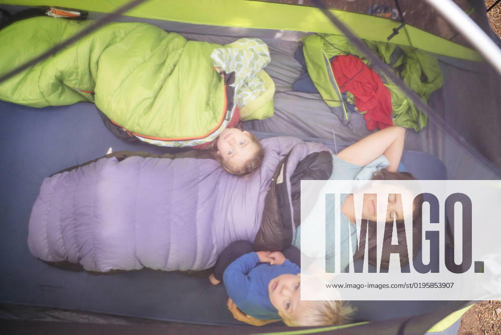 A mom and two young childen lie in their sleeping bags in a tent Maupin, Oregon, United States CR_AXTH22120116-1077437-01 ,model released, Symbolfoto