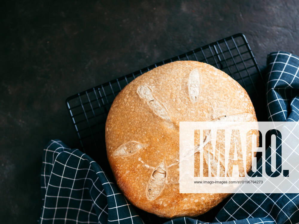 Wheat round sourdough bread, copy space, top view Wheat round sourdough bread. Top view of delicious homemade sourdough bread on black background with copy space. Home made sourdough bread making concept.