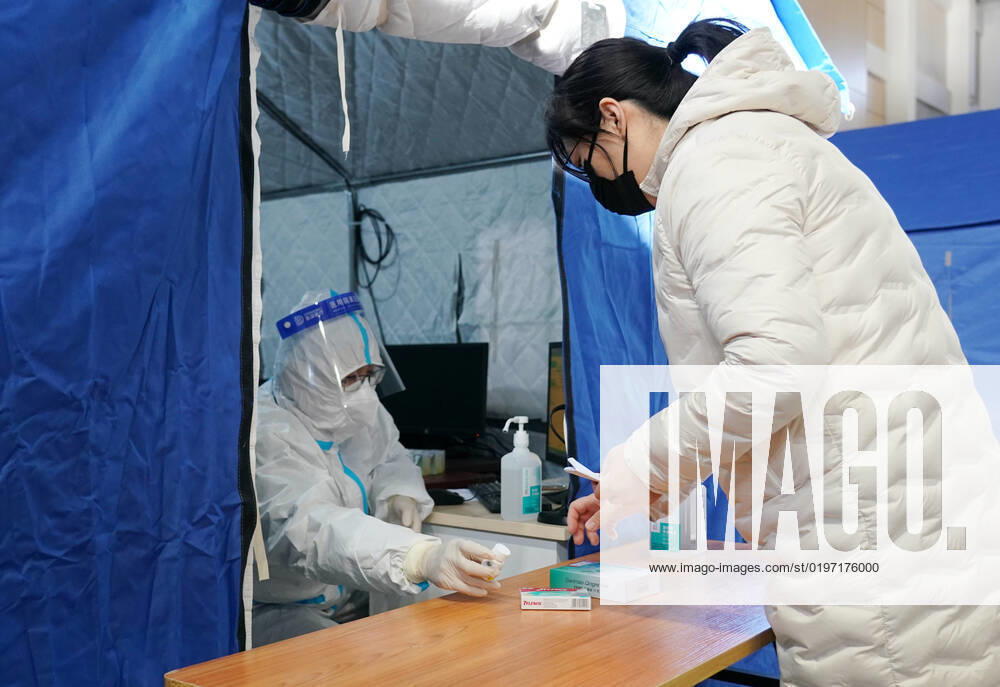 Coronavirus in China, provisorische Notunterkunft für Patienten mit Fieber in Peking (221224) -- BEIJING, Dec. 24, 2022 -- A medical worker passes medicine to a citizen in a makeshift fever clinic in Guang an Gymnasium in Beijing, capital of China, Dec. 24, 2022. In order to facilitate fever patients to seek medical treatment and ensure residents medical needs, some hospitals in Beijing set up makeshift fever clinics in gymnasiums to provide services such as diagnosis, prescription issuing and medicine dispensing for citizens. ) CHINA-BEIJING-GYMNASIUM-FEVER CLINIC (CN) ZhangxChenlin
