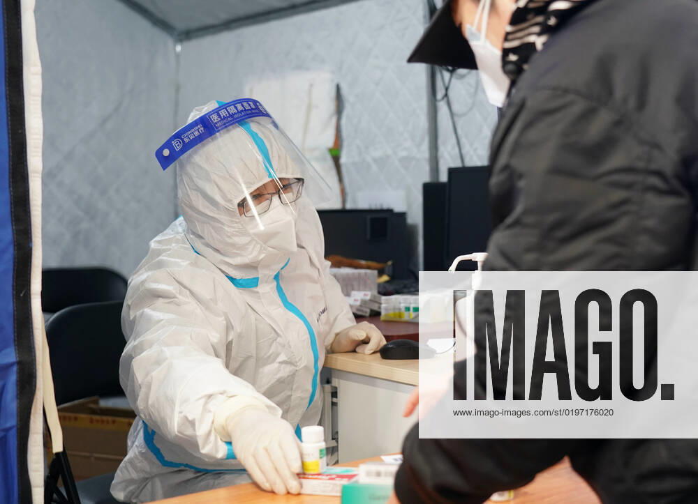 Coronavirus in China, provisorische Notunterkunft für Patienten mit Fieber in Peking (221224) -- BEIJING, Dec. 24, 2022 -- A medical worker passes medicine to a citizen in a makeshift fever clinic in Guang an Gymnasium in Beijing, capital of China, Dec. 24, 2022. In order to facilitate fever patients to seek medical treatment and ensure residents medical needs, some hospitals in Beijing set up makeshift fever clinics in gymnasiums to provide services such as diagnosis, prescription issuing and medicine dispensing for citizens. ) CHINA-BEIJING-GYMNASIUM-FEVER CLINIC (CN) ZhangxChenlin