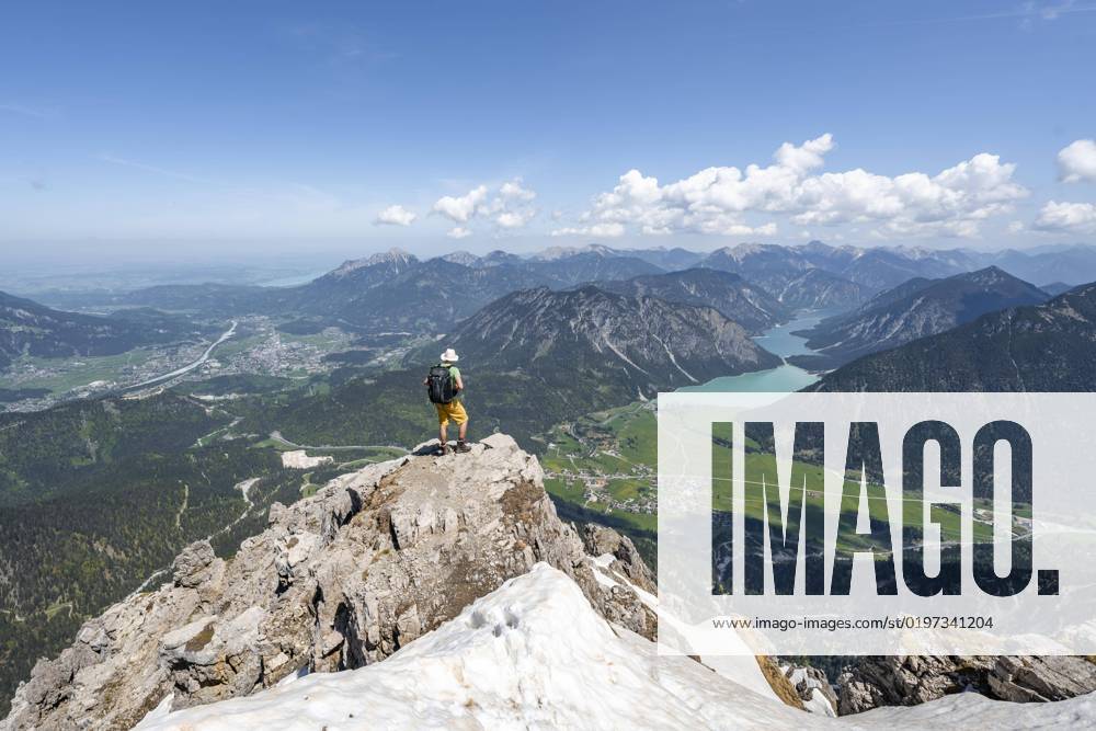 Wanderer am Gipfel des Thaneller, Ausblick auf Berge mit Plansee und Ort Reutte, Berglandschaft, Lechtaler Alpen, Tirol, Österreich, Europa