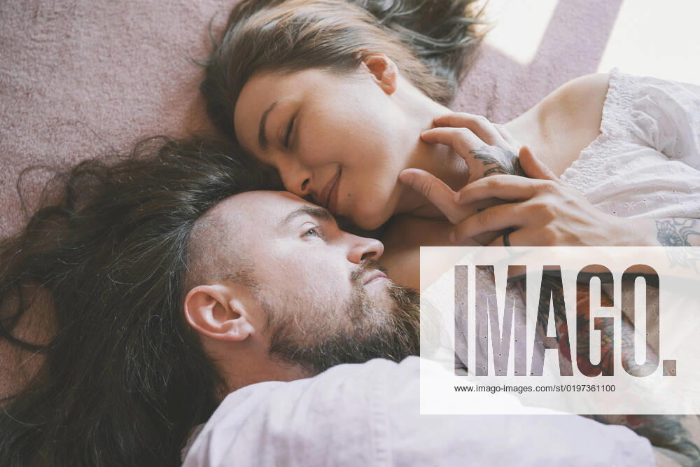 Romantic hipster couple lying on bed at home model released, Symbolfoto property released, NDEF00293