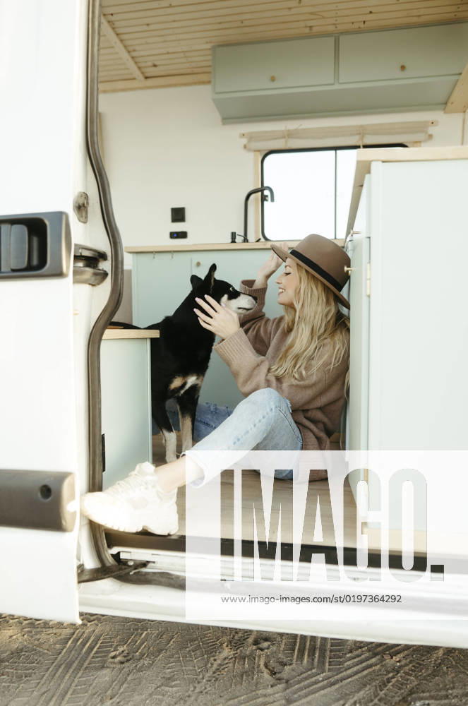 Young woman playing with dog inside motor home model released, Symbolfoto property released, RCPF01507