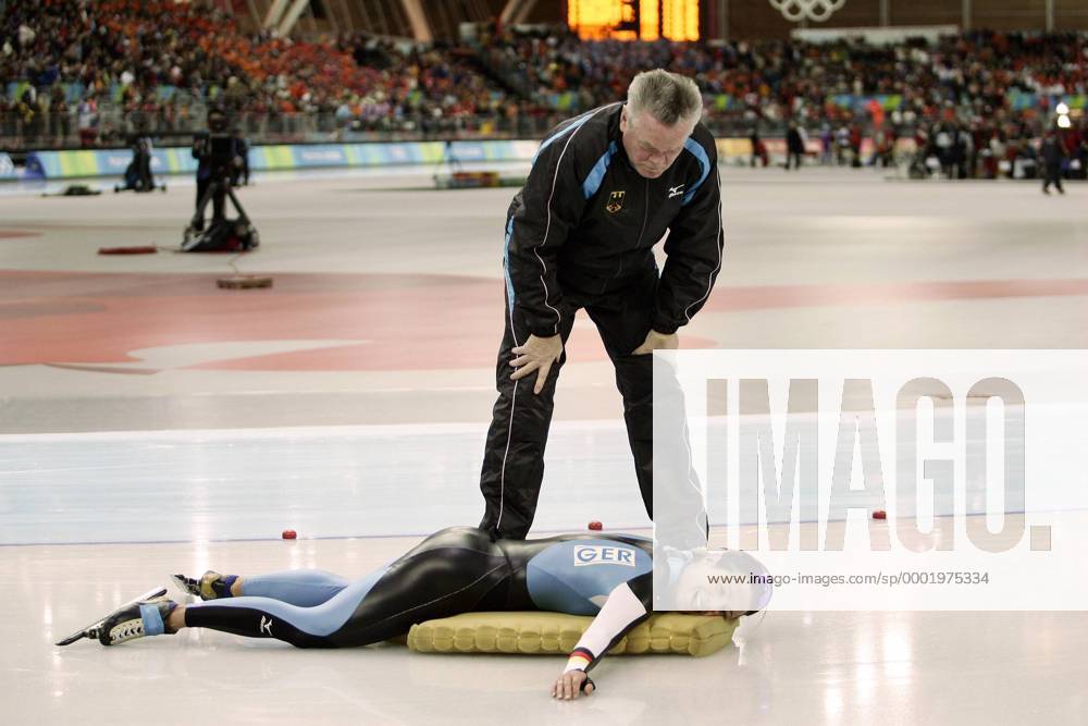 Claudia Pechstein liegt fix und fertig vor Bundestrainer Joachim Franke (beide Deutschland) auf ihrer Matte Eisschnellauf OS Winter Damen Olympische Spiele Turin 2006, Winterspiele, 5000m, 5000 m, Meter Gruppe Turin Erschöpfung,