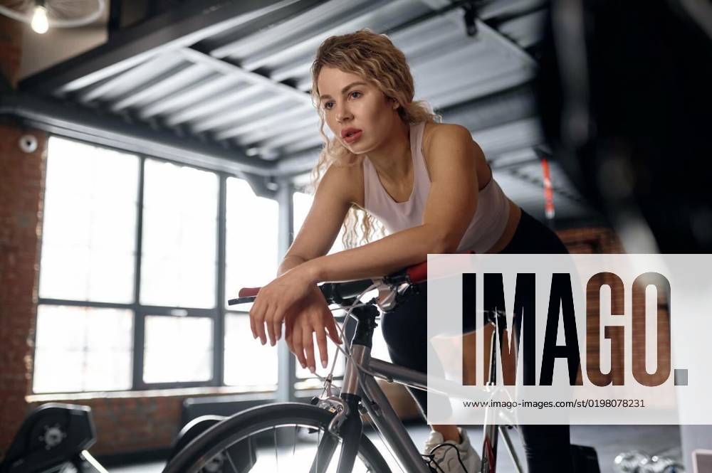 Exhausted woman on stationary bike in fitness studio, Exhausted woman on stationary bike in fitness studio after cycling class. Exhaustion at cardio training, Exhausted woman on stationary bike in fitness studio after cycling class. Exhaustion at cardio training, 05.10.2022,