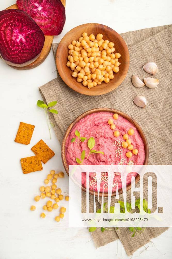 IMAGO Creative, Food, Hummus Hummus with beet and microgreen basil sprouts in wooden bowl on a white wooden background. Top view, close up., Hummus with beet and microgreen basil sprouts in wooden bowl on a white wooden background and linen textile. Top view, flat lay, close up., Hummus with beet and microgreen basil sprouts in wooden bowl on a white wooden background and linen textile. Top view, flat lay, close up., 24.10.2022,
