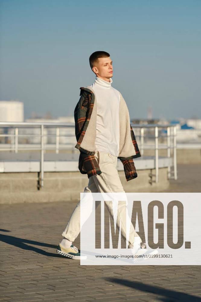 Young man in plaid jacket, white turtleneck and trousers walking on the street, Urban fashion. Young man in loose clothes walking on the street, Urban fashion. Young man in loose clothes walking on the street model released, Symbolfoto property released , 21.12.2022,