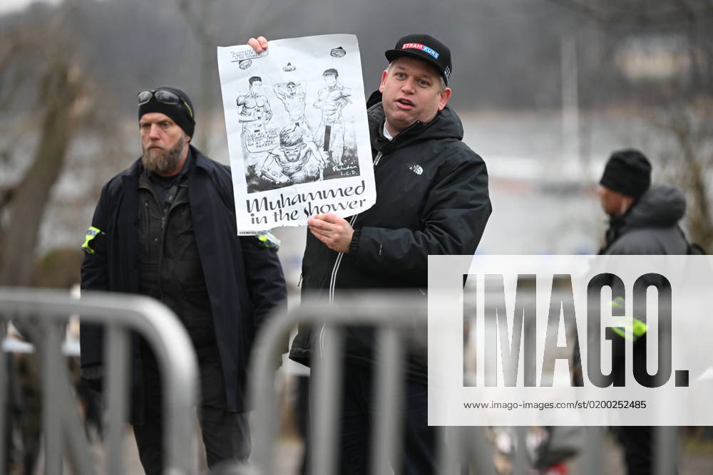 STOCKHOLM 20230121 Far-right politician Rasmus Paludan holds up a poster, drawing, as he holds a public rally near the Turkish embassy on Saturday STOCKHOLM SWEDEN