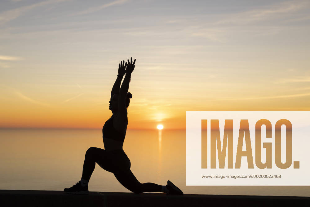 Woman with arms raised practicing yoga in front of sea model released, Symbolfoto, LJF02458