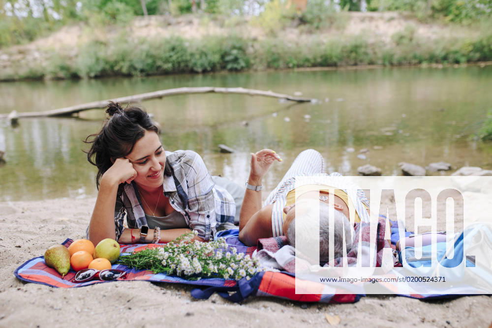 Young woman with friend relaxing at lakeshore in park model released, Symbolfoto, MRRF02548