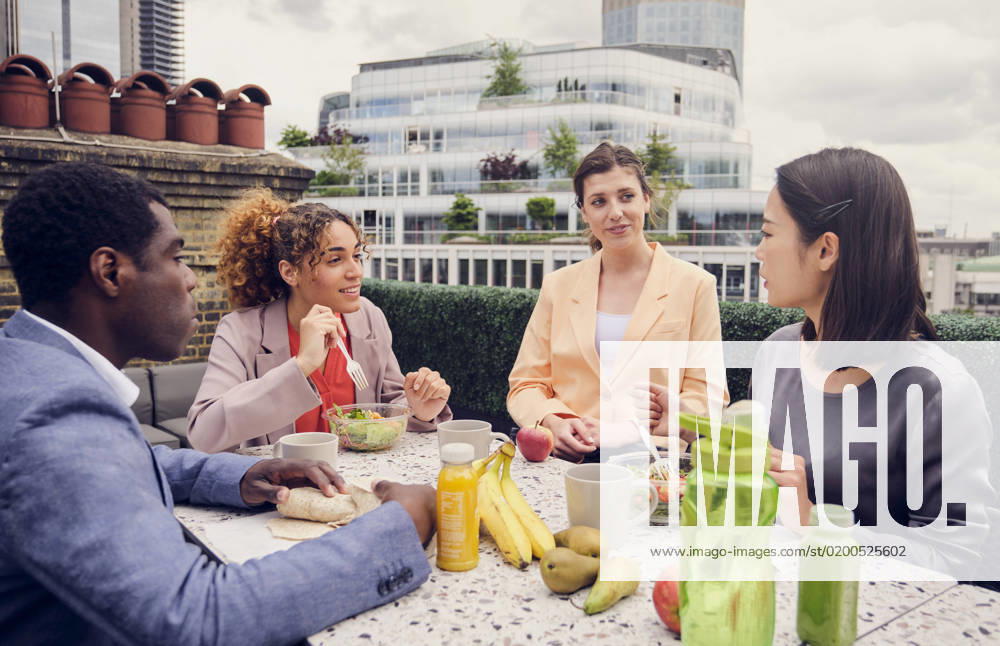 Businesswoman having lunch and talking with colleagues sitting at table model released, Symbolfoto property released, PWF00602