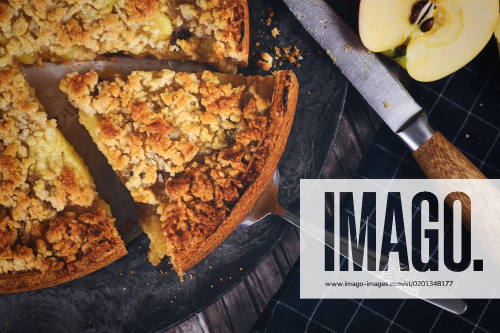 IMAGO Creative, Herbst, Food, Apfelkuchen Scheibe traditioneller europäischer Apfelkuchen mit Streuseln auf Tortenheber, umgeben von frischen Äpfeln und Messer
