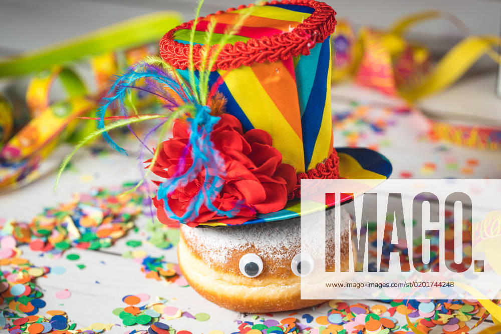 Krapfen Berliner dekoriert zu Rosenmontag, Fasching oder Karneval mit Luftschlangen, Kostüm und Konfetti