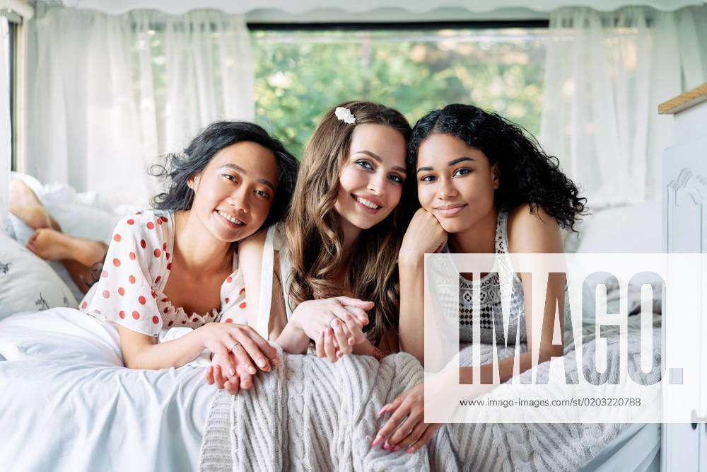 Multi ethnic group of women relax together during summer travel inside the camper van Multi ethnic group of women relax together during summer travel inside the camper van. Vacation, females friendship and beauty concept
