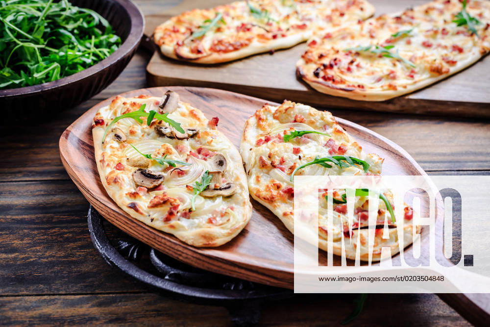 French tarte flambee with cream cheese, bacon and onions. Flammkuchen from Alsace region French tarte flambee with cream cheese, bacon and onions. Flammkuchen from Alsace region