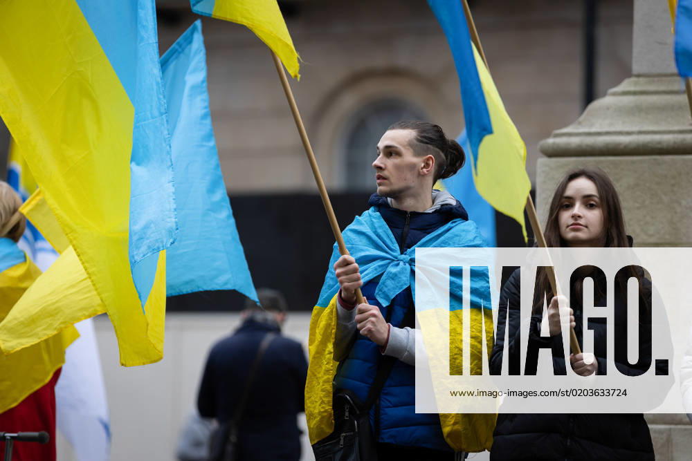 People hold Ukrainian flags as they observe a minute s silence in Whitehall opposite Downing Street in London. The world is marking the one-year anniversary of the full-scale Russian invasion of Ukraine today. London United Kingdom - ZUMAs197 20230224_zaa_s197_482