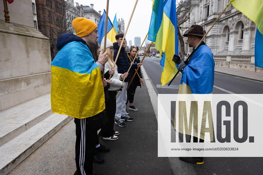 People hold Ukrainian flags as they observe a minute s silence in Whitehall opposite Downing Street in London. The world is marking the one-year anniversary of the full-scale Russian invasion of Ukraine today. London United Kingdom - ZUMAs197 20230224_zaa_s197_493