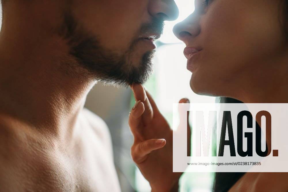 Man and woman kissing against a window with sunlight, erotica. Erotic scene, sexual relationship