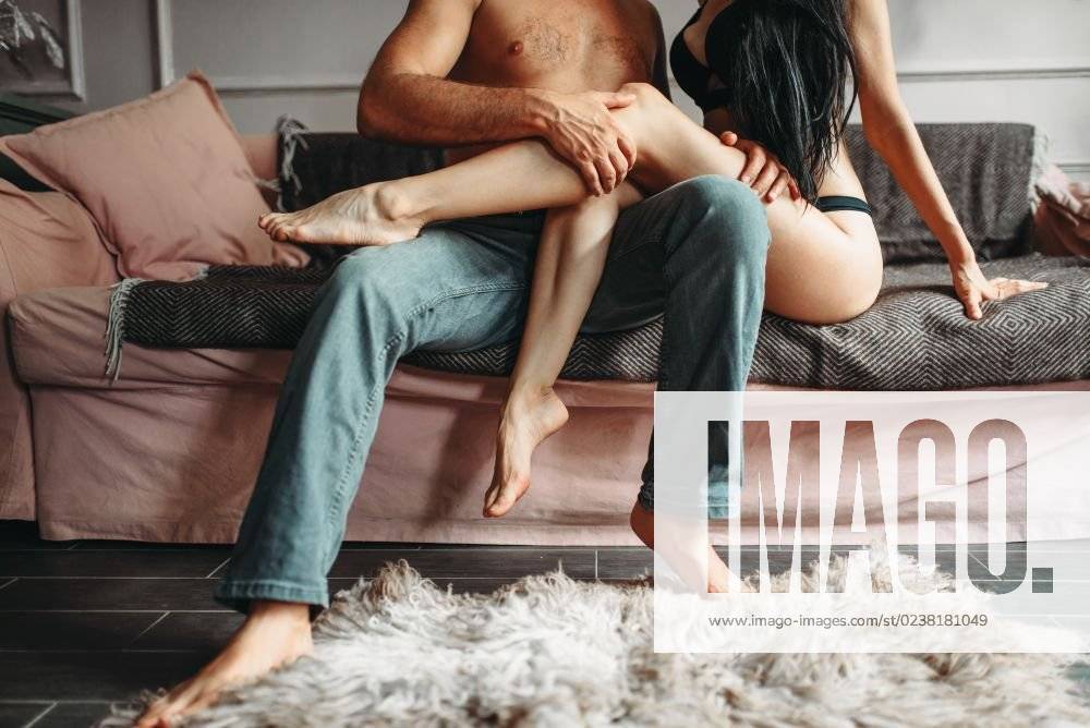Male and female person hugs on couch, seductive erotica. Erotic scene, sexual relationship of man and woman, love