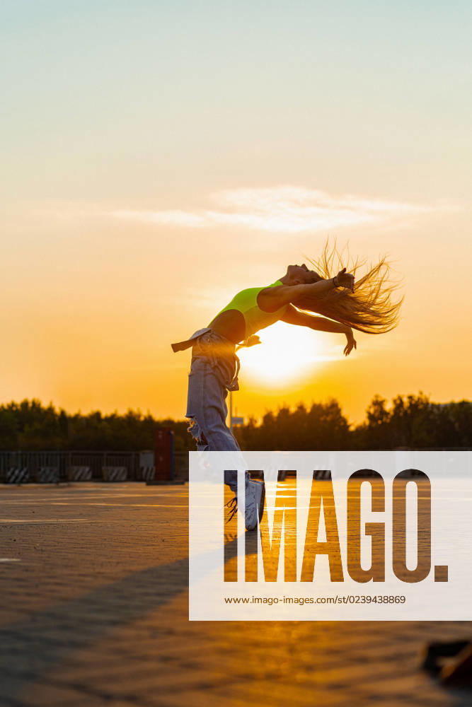 Woman dances at sunset, in motion, flying hair. California City, California, United States CR_YUKI230309-1148903-01 ,model released, Symbolfoto