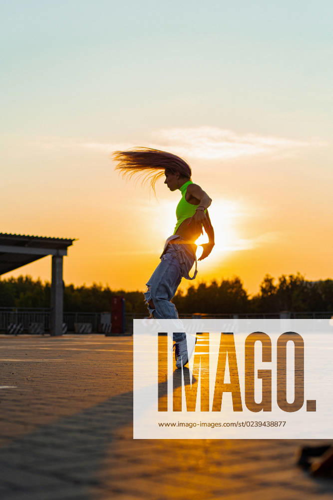 Woman dances at sunset, in motion, flying hair. California City, California, United States CR_YUKI230309-1148905-01 ,model released, Symbolfoto